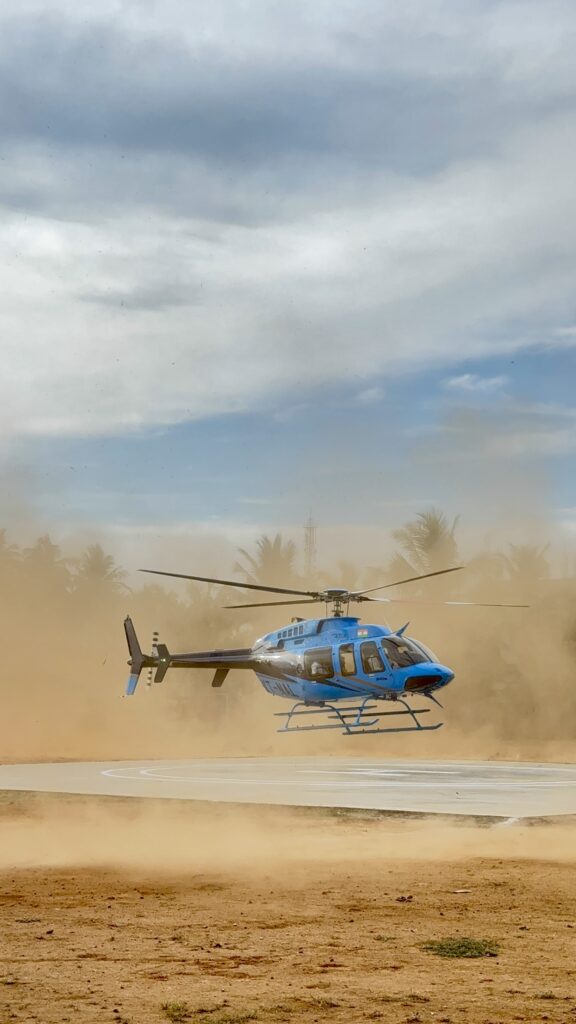 Nexus Private Charter Services 1 Stunning blue helicopter landing smoothly on a helipad against a clear sky.